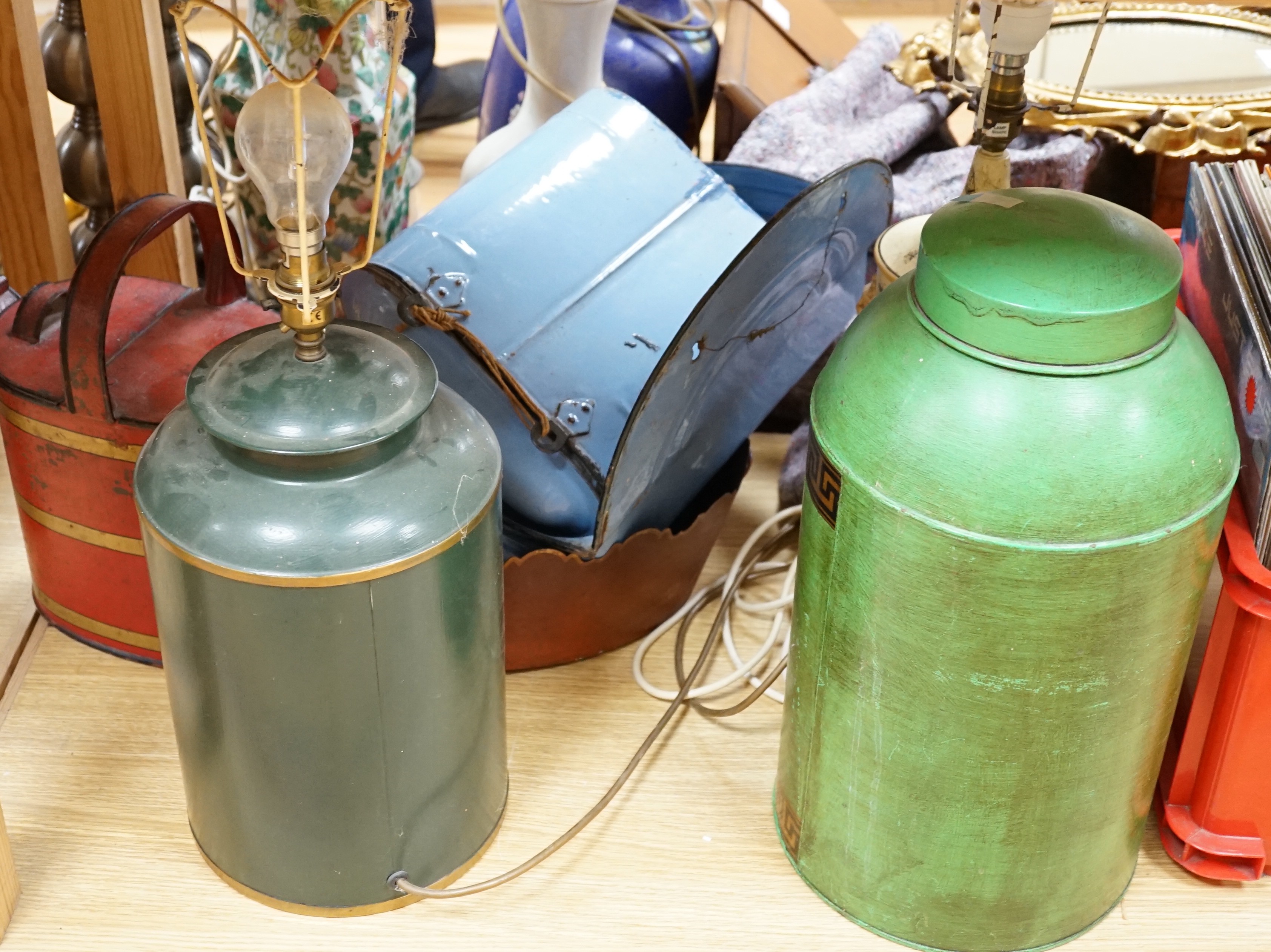 A collection of various toleware items, including two tea canisters, one mounted as a lamp, a watering can, etc